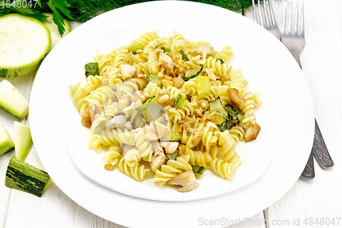Image of Fusilli with chicken and zucchini in two plates on white board