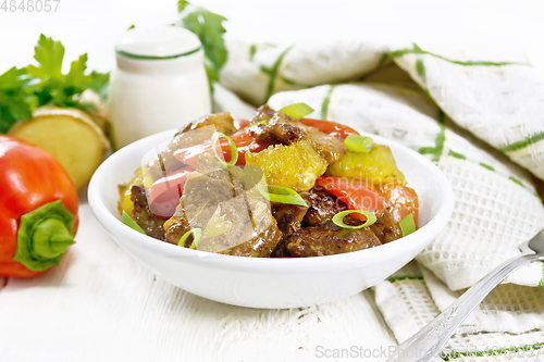 Image of Meat with oranges in bowl on board