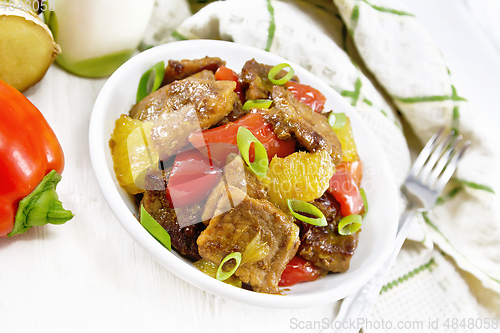 Image of Meat with oranges in bowl on wooden board