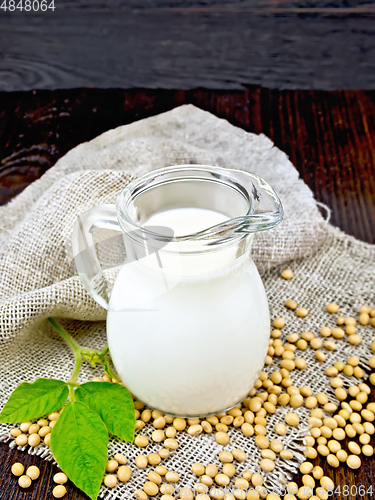 Image of Milk soy in jug with soybeans and leaf on board