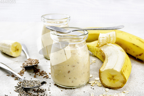Image of Milkshake with chia and banana in two jars on stone table