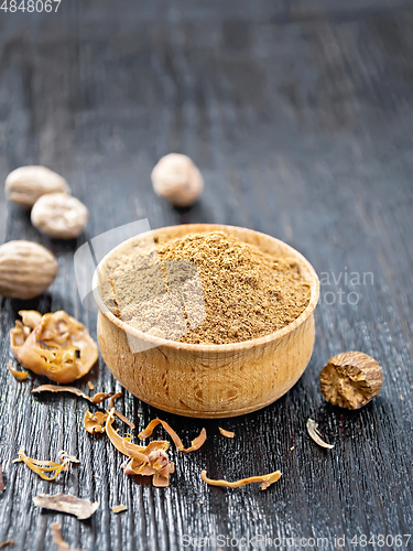 Image of Nutmeg ground in bowl on black wooden board