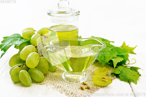 Image of Oil grape in gravy boat on light board