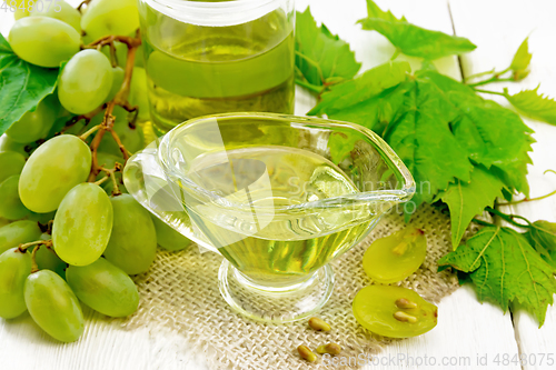 Image of Oil grape in gravy boat on white board