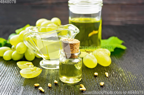 Image of Oil grape in vial on black wooden board