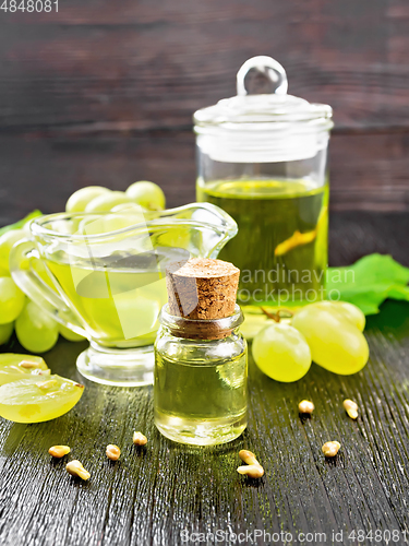 Image of Oil grape in vial on dark wooden board