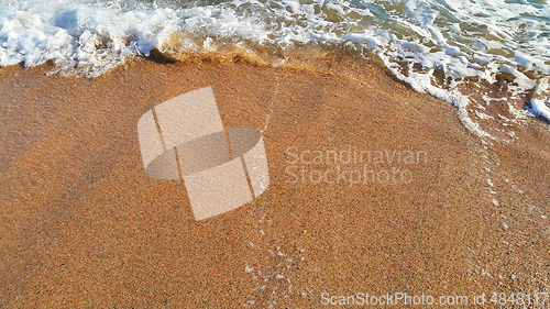 Image of Sandy beach background with white foam of sea wave