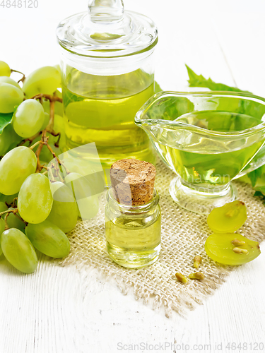 Image of Oil grape in vial on light wooden board