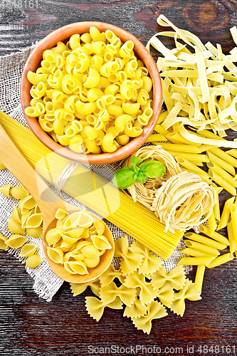 Image of Pasta different with basil on dark board top