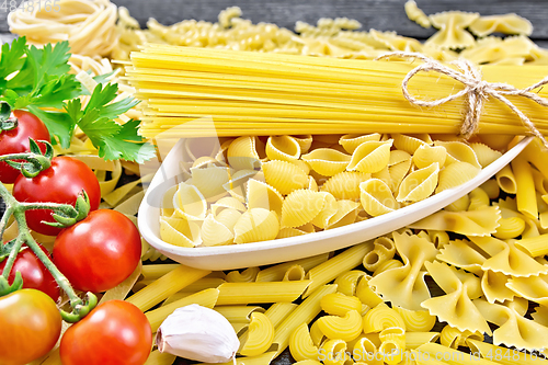 Image of Pasta different with bowl and tomatoes on board