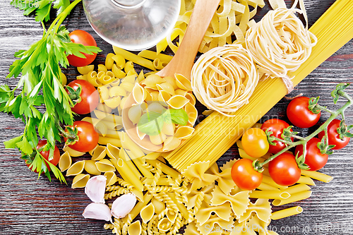 Image of Pasta different with oil and tomatoes on table top