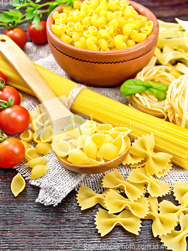 Image of Pasta different with tomatoes on wooden board
