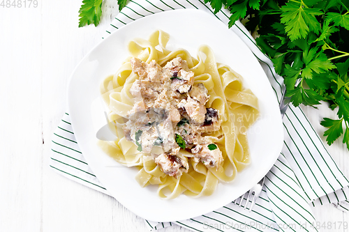 Image of Pasta with salmon in cream on light board top
