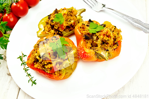 Image of Pepper stuffed with mushrooms and couscous in plate on light boa