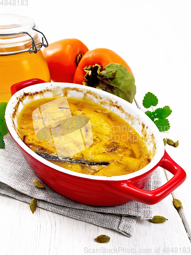 Image of Persimmons baked with honey in pan on table