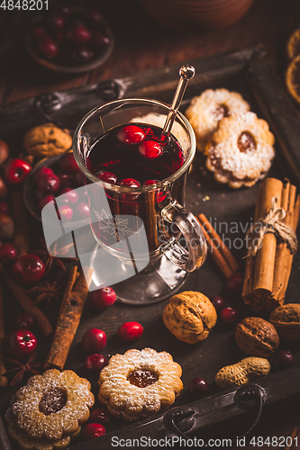 Image of Mulled wine with cranberry and spices, Christmas cookies and candles