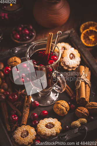 Image of Mulled wine with cranberry and spices, Christmas cookies and candles