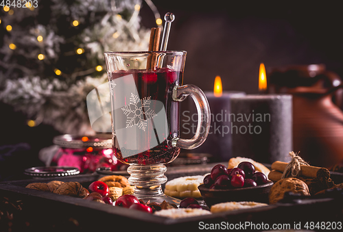 Image of Mulled wine with cranberry and spices, Christmas cookies and candles