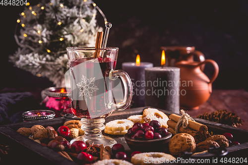 Image of Mulled wine with cranberry and spices, Christmas cookies and candles