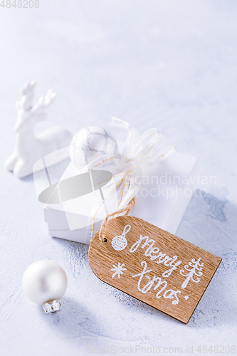 Image of Christmas ornaments and small present in white