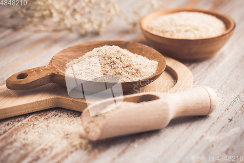 Image of Isabgol - heap of psyllium husk in wooden bowl on wooden table table