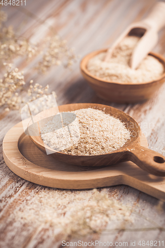 Image of Isabgol - heap of psyllium husk in wooden bowl on wooden table table