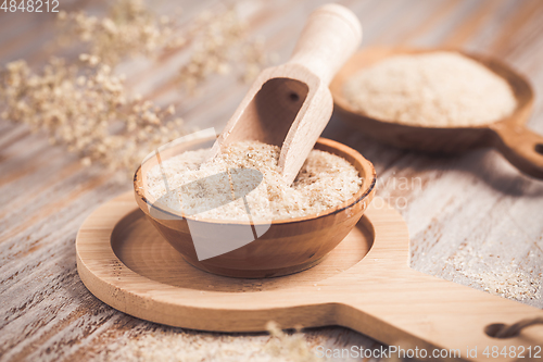 Image of Isabgol - heap of psyllium husk in wooden bowl on wooden table table