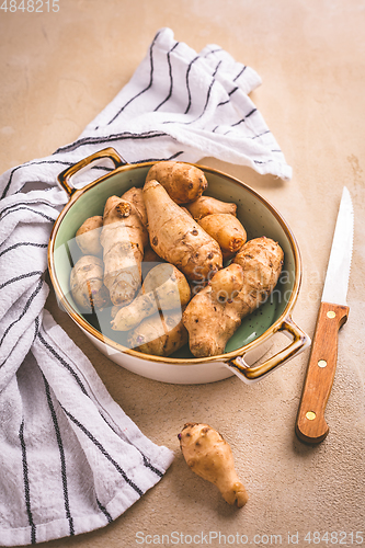 Image of Raw topinambour in bowl on kitchen table