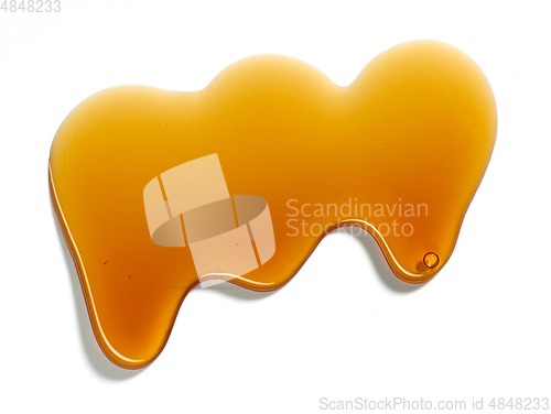 Image of flowing sugar syrup on white background