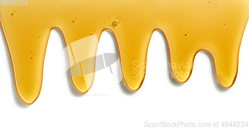 Image of flowing honey on white background