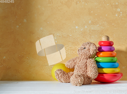 Image of old teddy bear and wooden toy on a wooden shelf