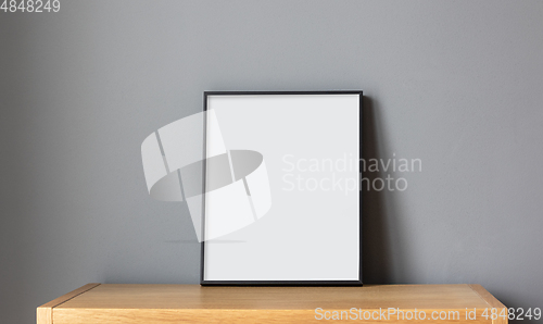 Image of empty frame on wooden shelf