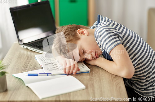 Image of tired student boy sleeping on desk at home