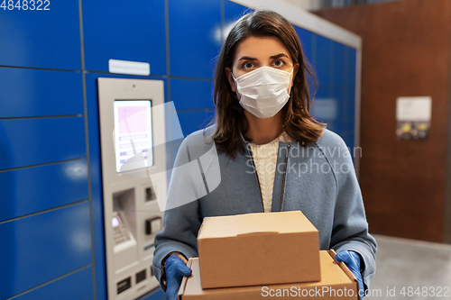 Image of woman in mask with boxes at parcel machine