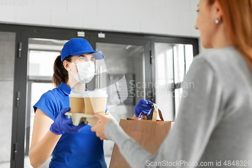 Image of delivery girl in mask giving paper bag to customer