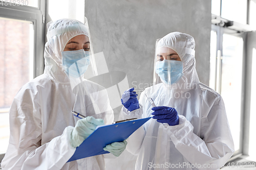 Image of doctors in medical mask and shield with clipboard