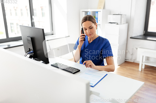 Image of doctor with computer calling on phone at hospital