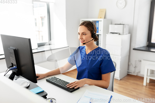 Image of doctor with headset and computer at hospital