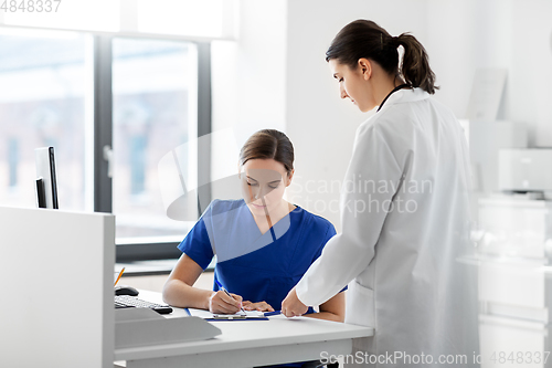 Image of doctor and nurse with clipboard at hospital