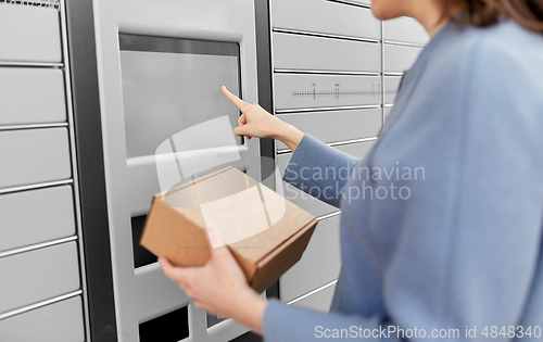 Image of smiling woman with box at automated parcel machine