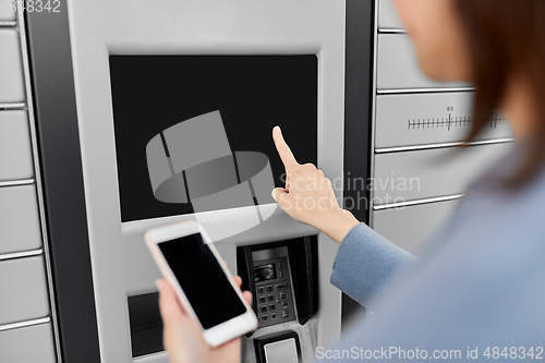 Image of woman with smartphone at automated parcel machine