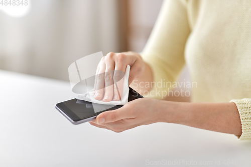 Image of close up of hands cleaning smartphone with tissue