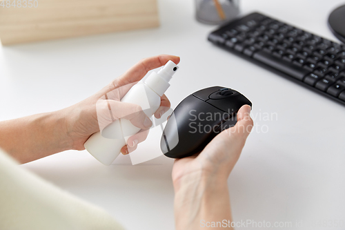 Image of close up of woman cleaning computer mouse