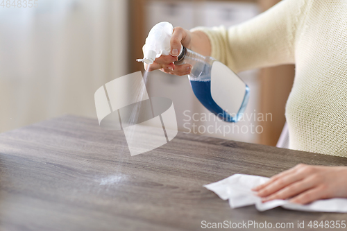 Image of close up of woman cleaning table at home