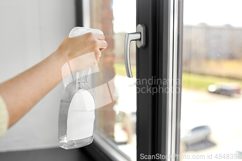 Image of hands cleaning window handle with detergent