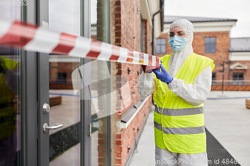 Image of healthcare worker sealing door with caution tape