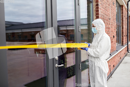 Image of healthcare worker sealing door with caution tape