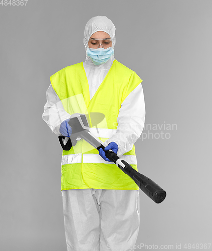 Image of sanitation worker in hazmat with pressure washer