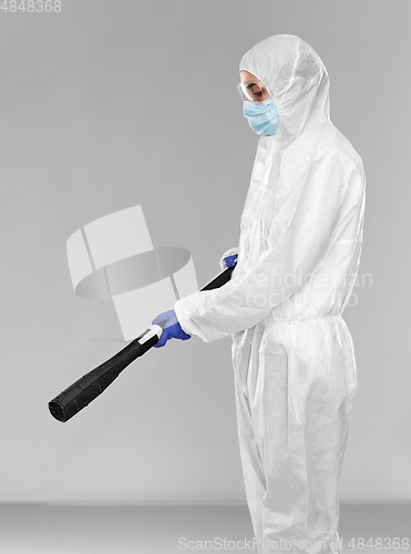 Image of sanitation worker in hazmat with pressure washer