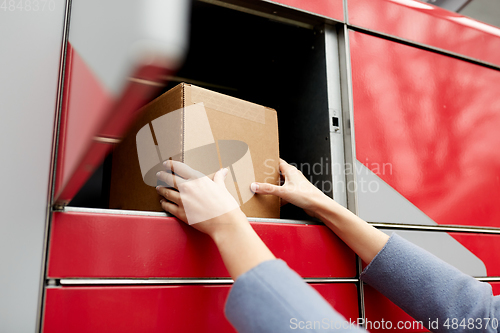 Image of woman putting box to automated parcel machine